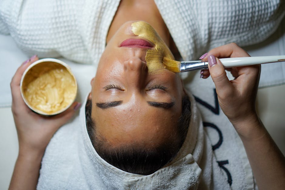 A woman enjoying a gold facial mask for relaxation and skincare at a spa