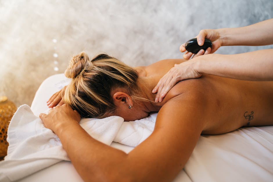 A woman enjoying a relaxing hot stone massage therapy session at a spa