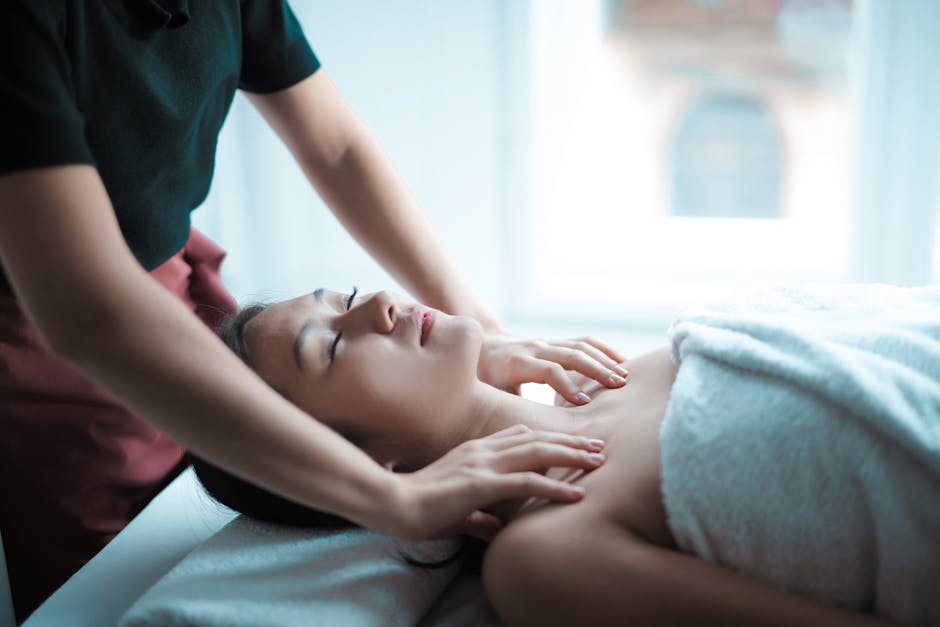 A serene spa massage session with a woman relaxing on a table, receiving a calming neck massage